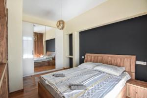 - une chambre avec un grand lit et un miroir dans l'établissement Ninoshvili's Painter's Home, à Tbilissi