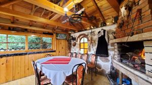 una sala da pranzo con tavolo, sedie e camino di Guest House Rila a Govedartsi