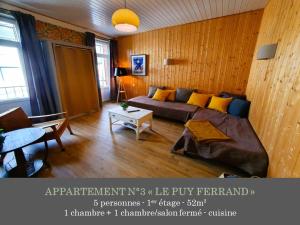 a living room with a bed and a table at La Maison des Familles 10 appartements in Le Mont-Dore
