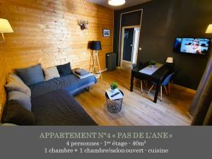 a living room with a blue couch and a table at La Maison des Familles 10 appartements in Le Mont-Dore