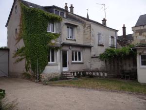 une vieille maison avec du lierre sur le côté dans l'établissement La Petite Treille, à Saint-Nicolas-de-Bourgueil