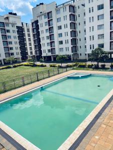 ナイロビにあるRacecourse one bed apartment ngong Roadの建物を背景にした大型スイミングプール
