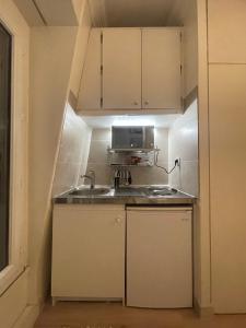a small kitchen with a sink and a microwave at Dream Dwell Paris-Charming Studio superb location in 7th district Paris in Paris