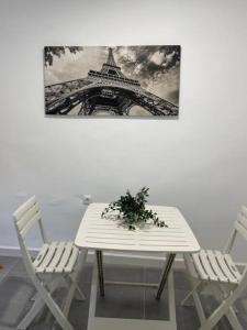 una mesa y sillas blancas con una foto de la torre Eiffel en Confortable adosado en Elche en Elche