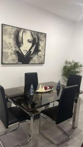 une salle à manger avec une table et des chaises en verre dans l'établissement Confortable adosado en Elche, à Elche