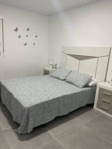 a bedroom with a bed with butterflies on the wall at Confortable adosado en Elche in Elche