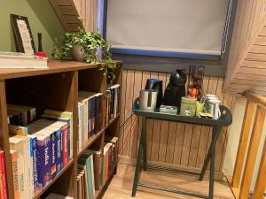 einen Tisch neben einem Bücherregal mit Büchern in der Unterkunft CasaDeKaMa in Evergem