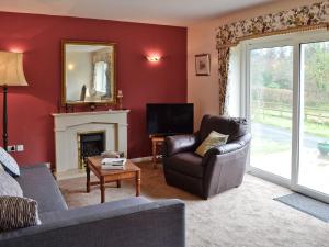 a living room with a couch and a fireplace at Whitegate View in South Chard