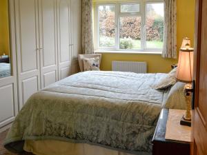a bedroom with a bed and a window at Whitegate View in South Chard