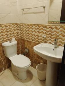 uma casa de banho com um WC e um lavatório em احلام الشاطئ للشقق المفروشة em Ar Ruʼays