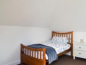een slaapkamer met een houten bed en een nachtkastje bij Reeds Farmhouse in Bentley
