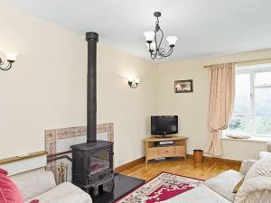 a living room with a wood stove in it at Garburn View in Kentmere