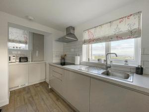 een keuken met een wastafel en een raam bij Willow Cottage in Sandwick