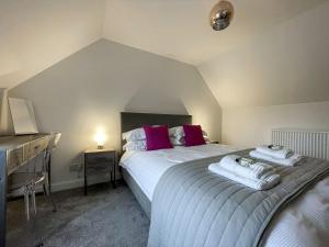 Willow Cottage في Sandwick: غرفة نوم بسرير كبير ومخدات حمراء