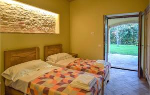 a bedroom with two beds and a door to a yard at Awesome Apartment In Avigliano Umbro With 2 Bedrooms And Wifi in Avigliano