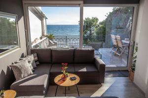 a living room with a couch and a view of the ocean at Kalafatis beach home in Itea