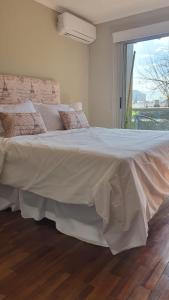 ein großes weißes Bett in einem Schlafzimmer mit Fenster in der Unterkunft Departamento Caseros in Salta