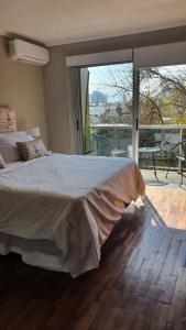 a bedroom with a large bed and a large window at Departamento Caseros in Salta