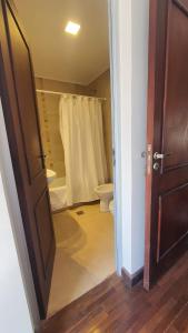 baño con ducha, aseo y puerta en Departamento Caseros en Salta