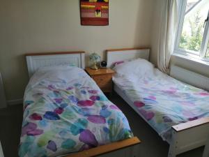um quarto com 2 camas e uma janela em Curlews Cottage - House with 3 bedrooms and garden - walking distance to the beach em Perranporth