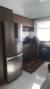 una cocina con nevera y electrodomésticos de acero inoxidable en Duplex-318 até 8 pessoas, en Florianópolis
