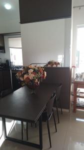Una mesa negra con un jarrón de flores. en Duplex-318 até 8 pessoas, en Florianópolis