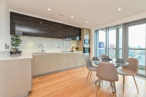 a kitchen and dining room with a table and chairs at CannySuite 1BED in London