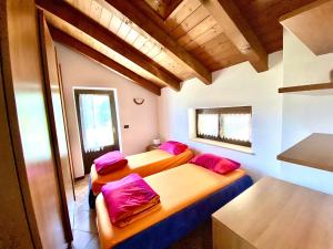 2 letti in una piccola camera con cuscini rossi di Villa di Charme a Gignod