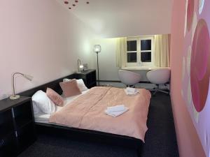 1 dormitorio con 1 cama con 2 sillas y una ventana en Penzion a Restaurace 14, en Hostinné