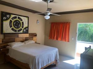 Schlafzimmer mit einem Bett und einem Deckenventilator in der Unterkunft Hotel Cambri in Nagua