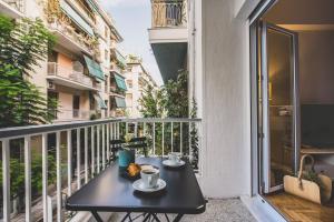 a table on a balcony with two cups of coffee at 90m2 Luxury Apartment in the Heart of Athens - Living Stone Sunstone in Athens