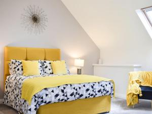 a bedroom with a bed with a yellow headboard at The Coach House At Mount Pleasant in New Shildon