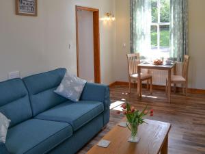 a living room with a blue couch and a table at The Waiting Rooms in Cawston