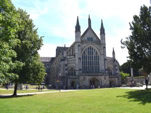 une grande cathédrale avec une pelouse devant elle dans l'établissement The Hideaway, à Breamore