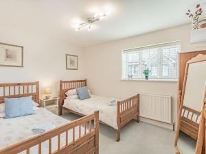 a bedroom with two beds and a window at Tea Pot Cottage in Ringwood