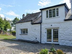 a white stone house with a large window at Uk40278 - Llys Elen One in Brynsiencyn