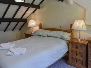 a bedroom with a bed with two lamps on night stands at Uk40278 - Llys Elen One in Brynsiencyn
