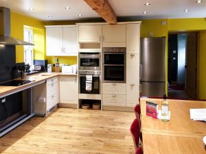 a kitchen with white cabinets and stainless steel appliances at The Moat House in Annan