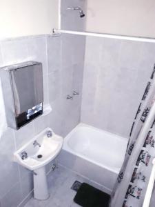 a white bathroom with a sink and a shower at Hotel Central in Buenos Aires