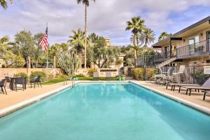 a swimming pool with tables and chairs in front of a building at Scottsdale Condo about 2 Mi to Downtown! in Scottsdale