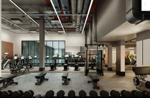 a gym with rows of exercise equipment in a building at One and Two Bedroom Apartments at Coppermaker Square in Lively Stratford in London