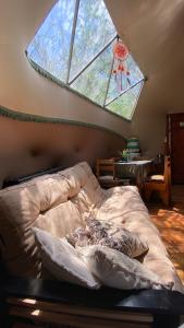 a bedroom with a bed and a large window at Domo Cielos del Uritorco in Capilla del Monte