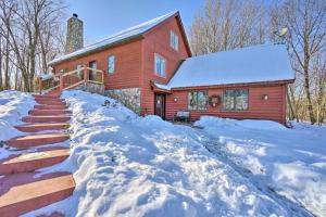 a red house with snow in front of it at Secluded Ellsworth Apartment - Hiking Nearby! 