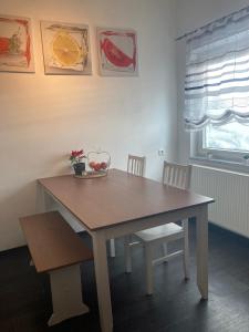 una mesa de madera con 2 sillas y un bol de fruta. en Ferienwohnung Lipp, en Waldstetten