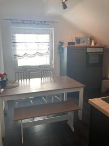 a table and bench in a kitchen with a window at Ferienwohnung Lipp in Waldstetten