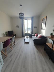 salon z kanapą i stołem w obiekcie Appartement au cœur du village d'Aufferville w mieście Aufferville +4 zdjęcia
