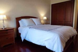 a bedroom with a large white bed with two lamps at SeaBreezeBonimar in Funchal