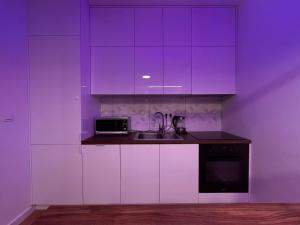 - une cuisine violette avec un évier et un four micro-ondes dans l'établissement Apartament Sophie - Samozameldowanie - Self check-in, à Rzeszów