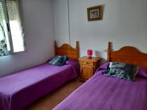 アルファス・デル・ピにあるChalet luminosoの紫のシーツが備わる客室内のベッド2台
