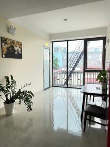 ein Wohnzimmer mit einem Tisch und einem Balkon in der Unterkunft Pharma Hotel in Diện Biên Phủ